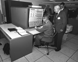 U.S. Department of Agriculture (USDA) Statistical Reporting Service (SRS) Administrator Harry Trelogan looks on as Agriculture Secretary Orville Freeman tests out some of the functions of the IBM 360 computer in this 1966 photo. Image source: Wikimedia Commons
