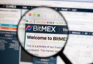 Bitmex logo on a computer screen with a magnifying glass