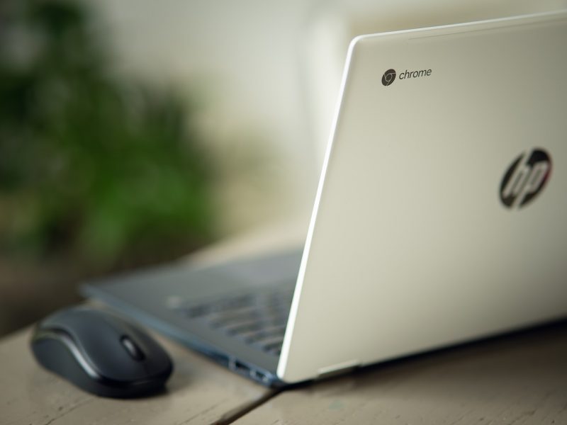 Chromebook laptop computer sitting next to a mouse on an office desk setting