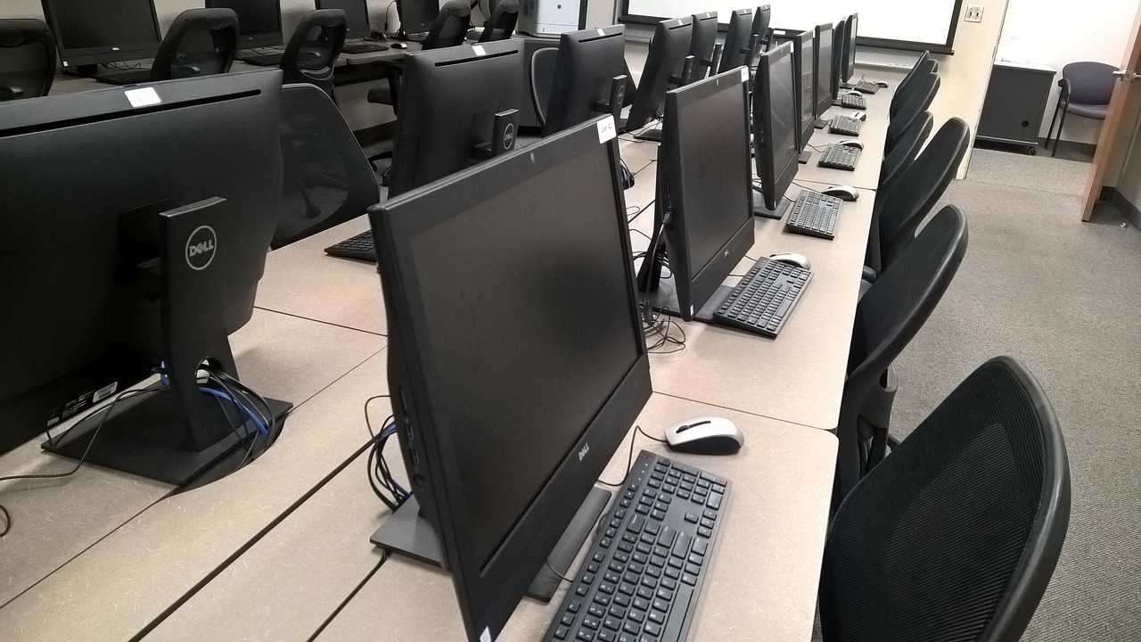 A row of Dell computers and monitors in an education computer lab.