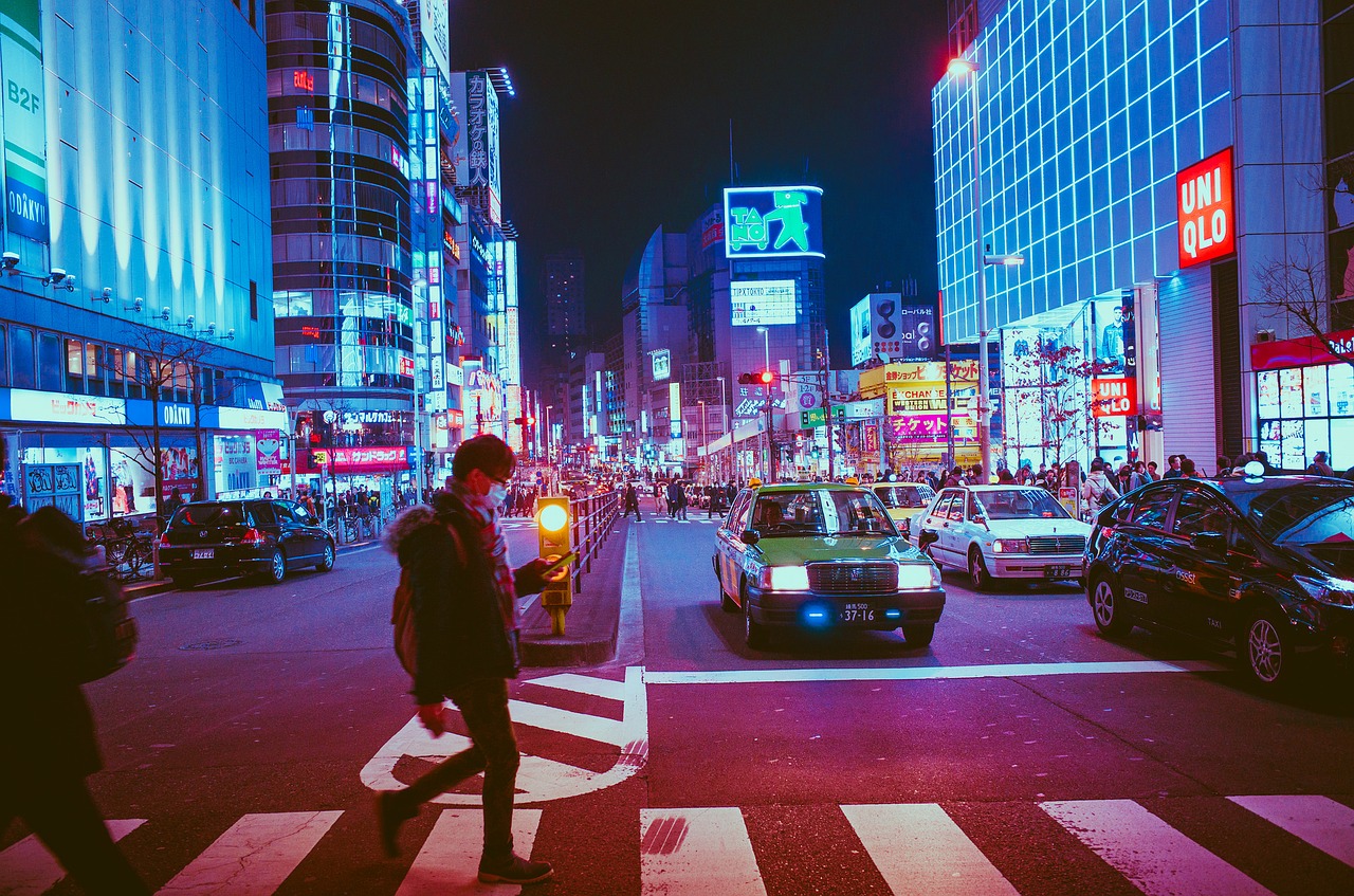 Pedestrians walking in a neon lit street at night in Osaka, Japan