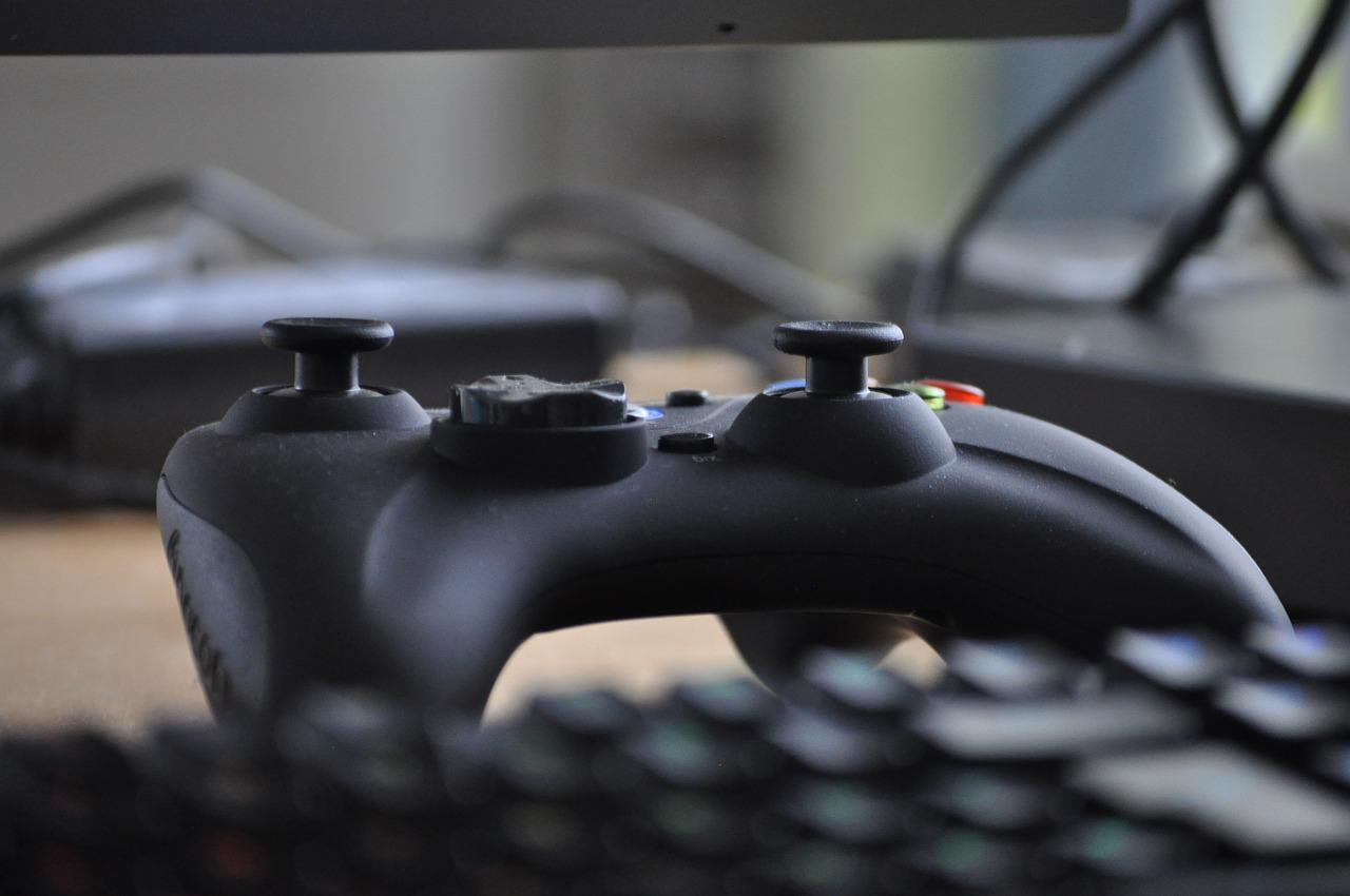 A keyboard and a game controller sitting on a table.