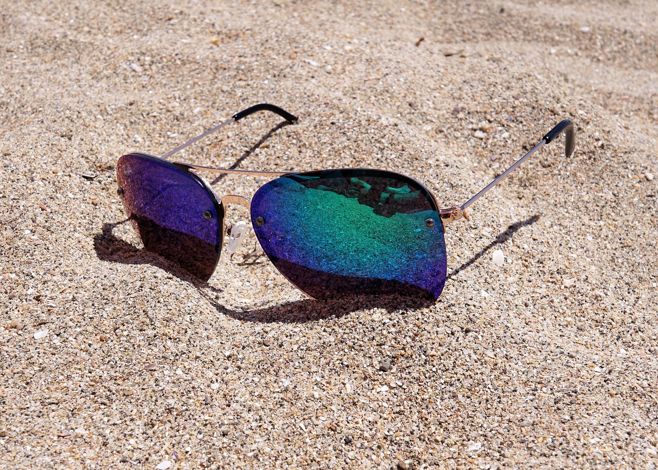 sunglasses sitting on a beach in the sand