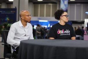 Travis Johnson, Level 3 engineer at Convo Communications LLC, Destiny O'Connor, co-chair of the Deaf and Hard of Hearing Working Group, talk with theCUBE during KubeCon + CloudNativeCon NA